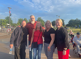 Huskie Marching Band alumni members pose for photo at an MBAC event