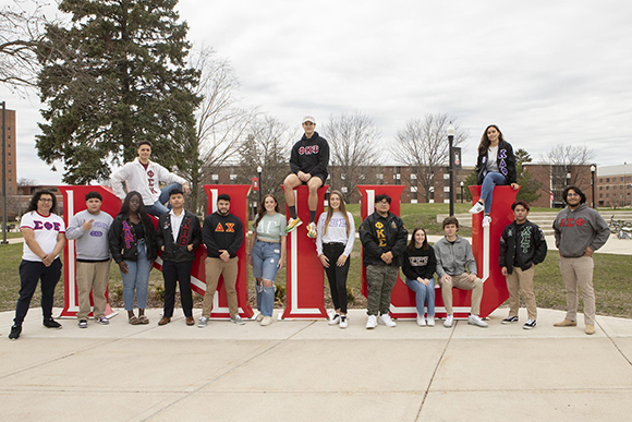 NIU Students in Fraternities and Sororities pose for a photo at the NIU Pride sculpture in the MLK Commons