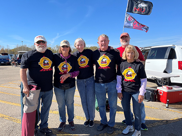 Small group of Golden Huskies wearing matching Golden Huskies tee-shirts at an NIU tailgate event.