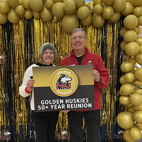Glenn, '73, and Sharon, '92, Hollister pose for a photo at the Golden Huskie 50+ Reunion in 2023.