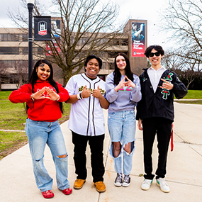 Four members of NIU greek organizations posing in the MLK commons