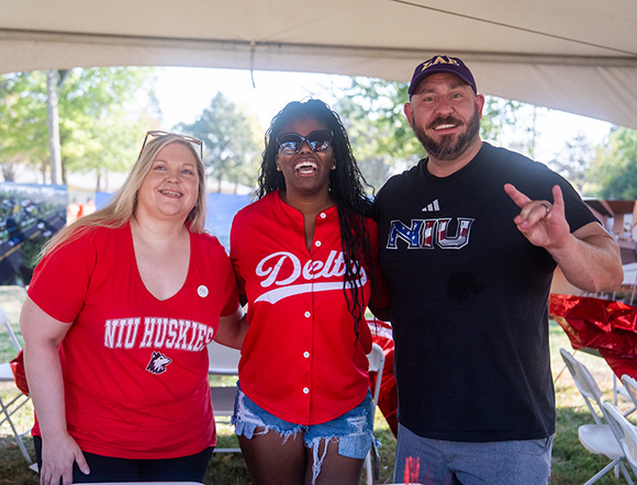Three NIU Greek Alumni enjoying tailgating at Homecoming