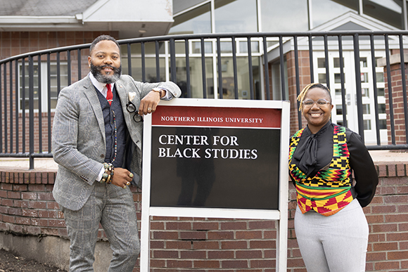 Christopher Mitchell, Ph.D. and T. Ajewole Duckett, Ph.D., MFA, pose by the sign in front of the NIU Center for Black Studies on the DeKalb, Illinois campus.